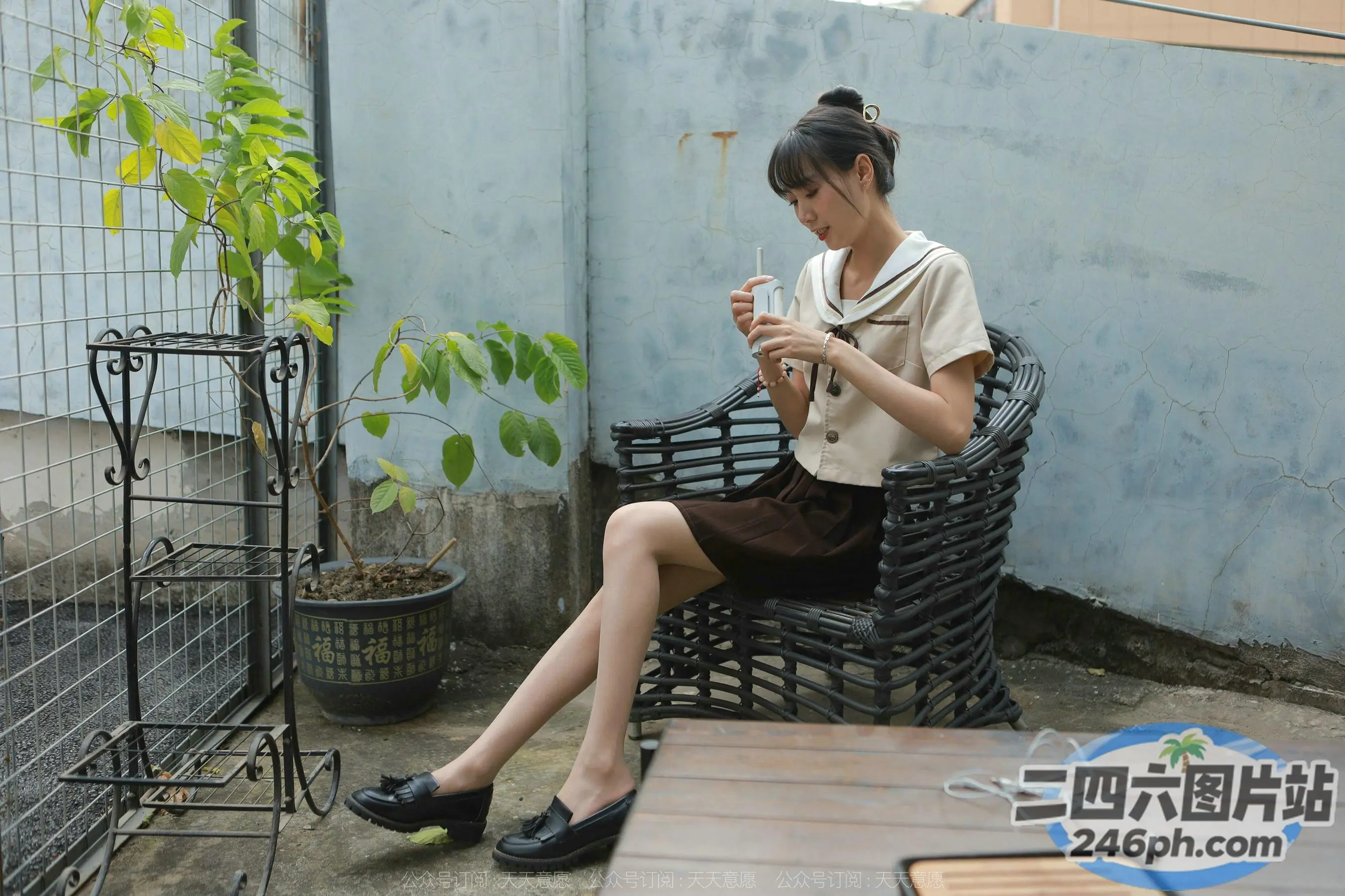 有个女人坐在长凳上，手里拿着一杯饮料