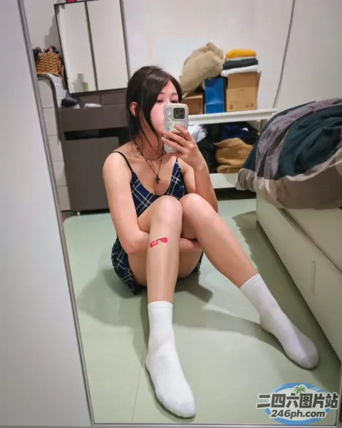 坐在地板上对着镜子自拍的 Araffe 女子