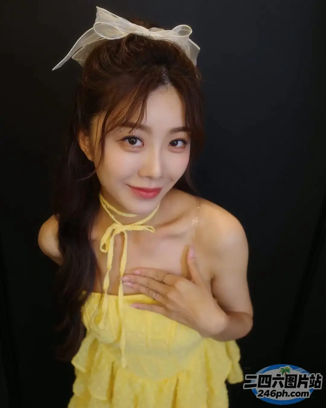一名身穿黄色连衣裙的女子摆姿势拍照的特写