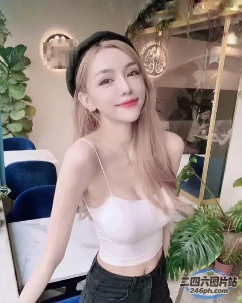 一位身穿白色上衣和黑色裤子的女子摆姿势拍照