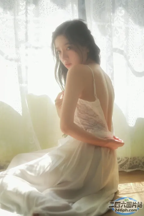 地板上坐着一个穿着白色连衣裙的女人