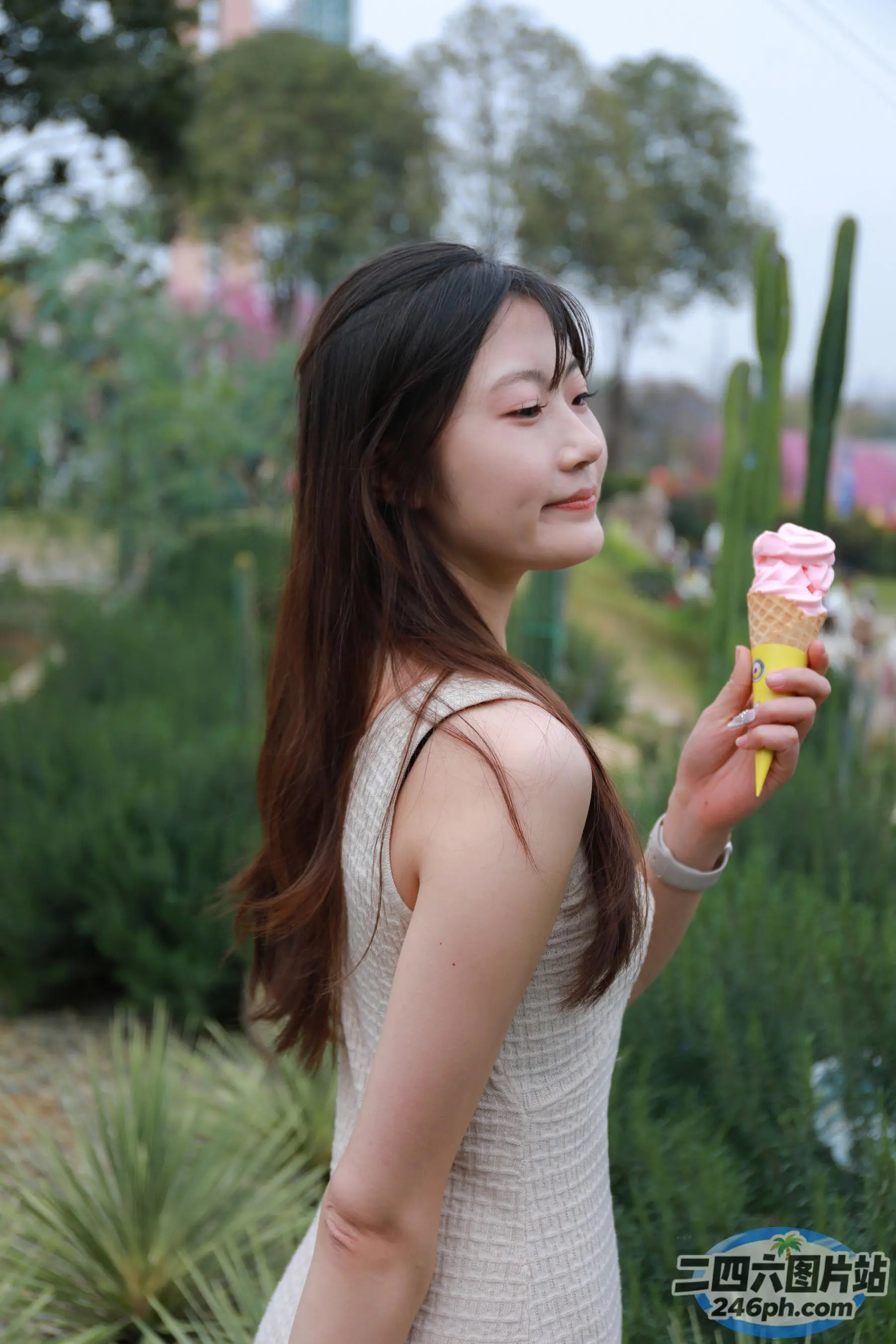 阿拉菲女人手里拿着一个粉红色的冰淇淋甜筒