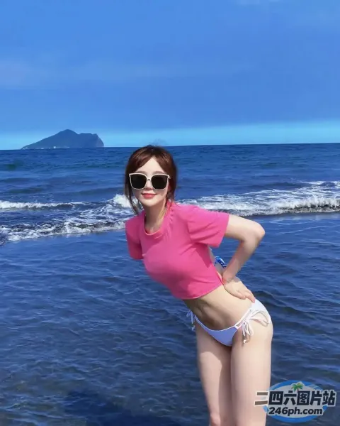 海滩上有个穿着粉色衬衫和白色短裤的女人
