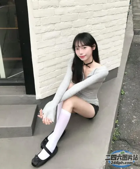 一名女子双腿交叉坐在建筑物的台阶上