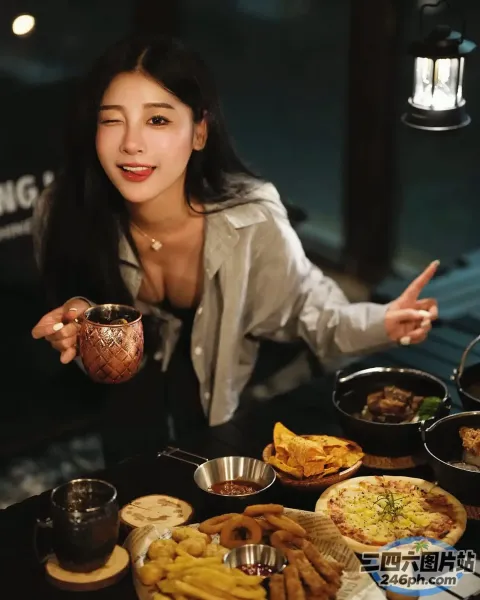女人坐在一张桌子旁，桌上摆放着各种食物和饮料