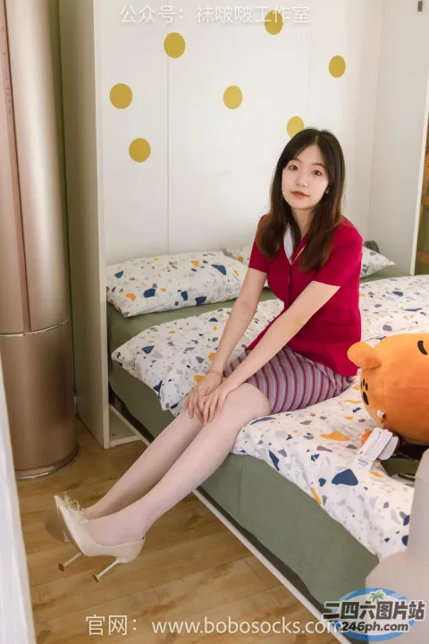 Araffe 坐在床上，手里拿着一只泰迪熊和一件红色衬衫