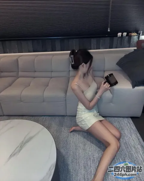 有个女人坐在沙发上，手里拿着手机