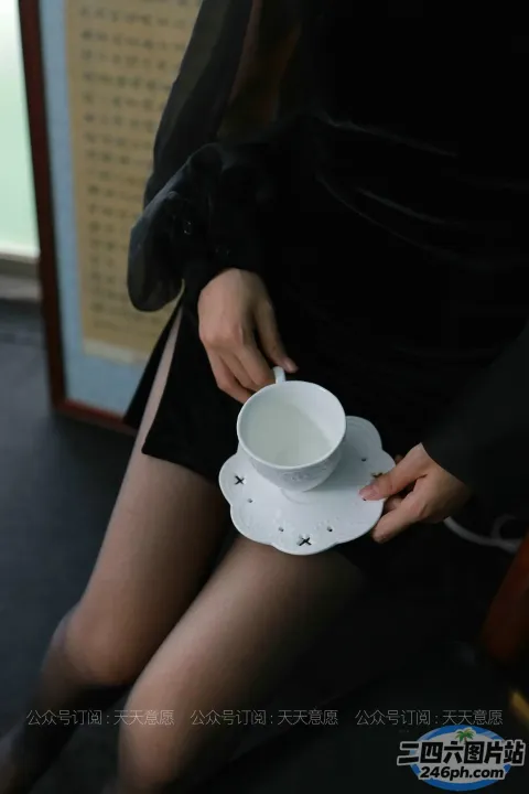 有一个女人手里拿着杯子和碟子
