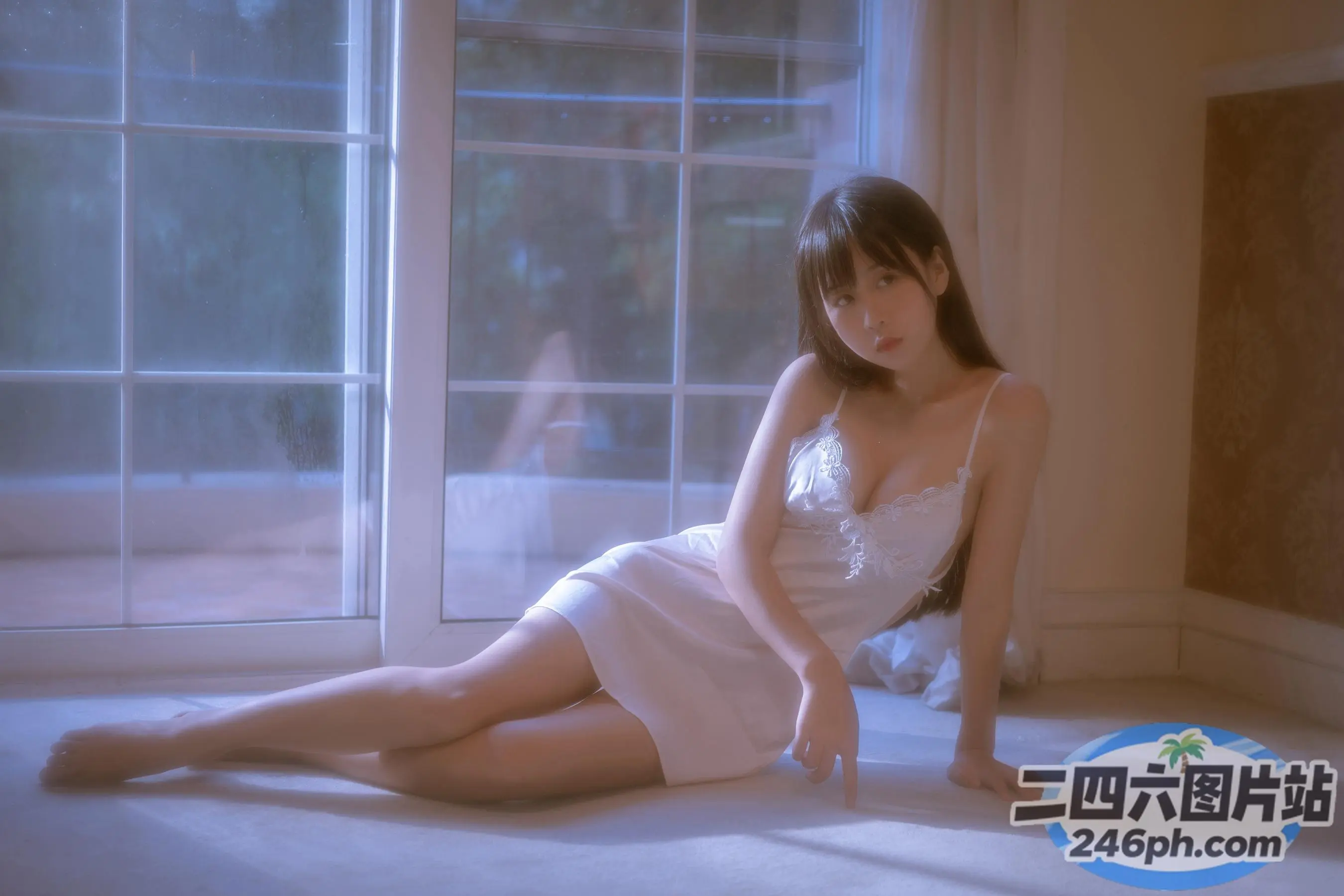 地板上坐着一个穿着白色连衣裙的女人