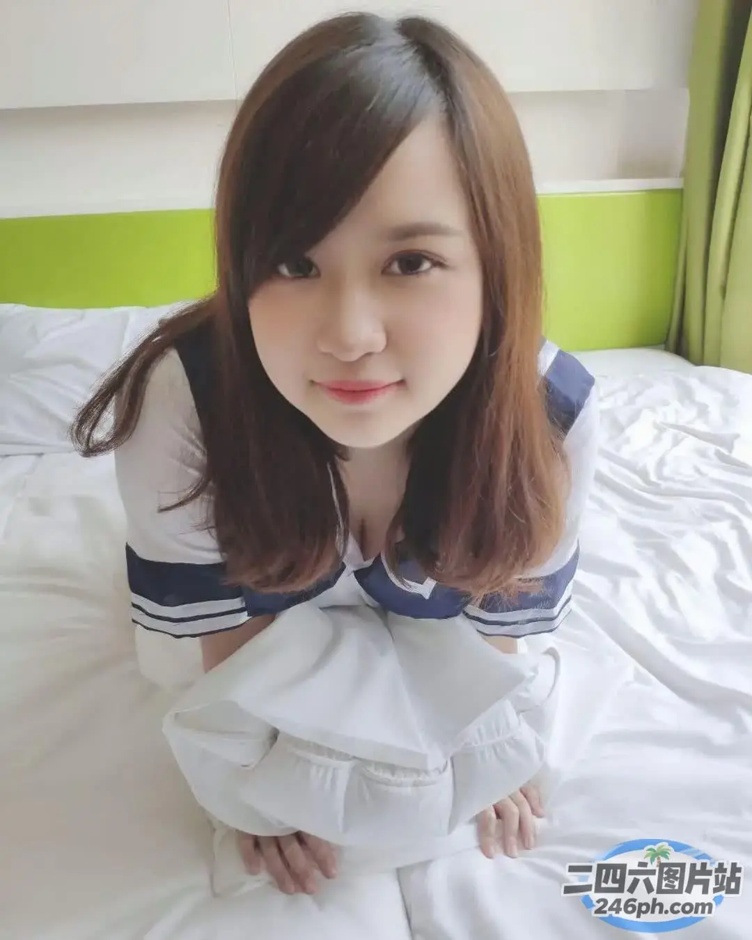 阿拉夫德亚洲妇女坐在床上，盖着一条白色的毯子