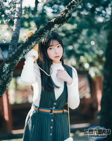 一个穿着裙子的女人拿着一只泰迪熊的特写