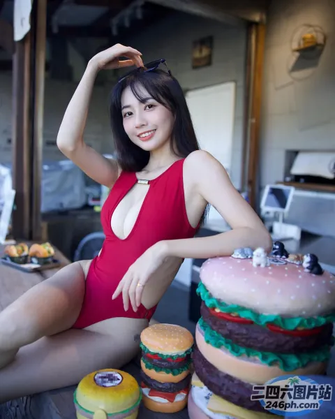 身穿红色泳衣的 Araffe 女子坐在桌子上，手里拿着汉堡蛋糕