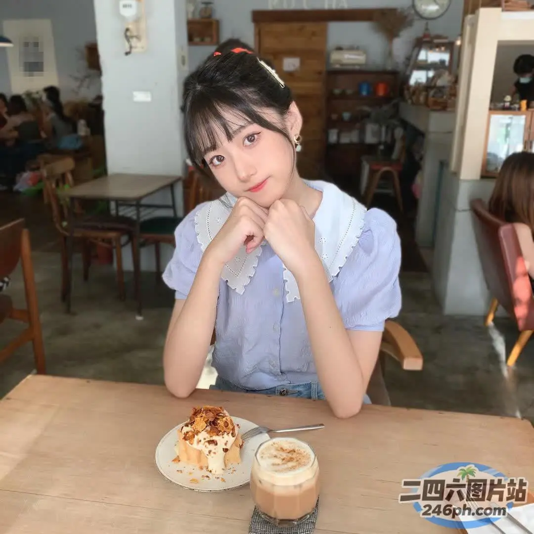 有个女人坐在一张桌子旁，桌上放着一盘食物