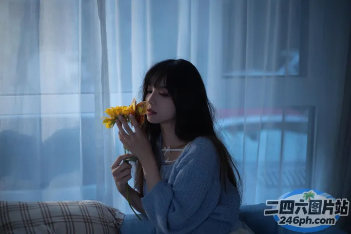 阿拉菲女人坐在沙发上，手里拿着一朵花，站在窗前