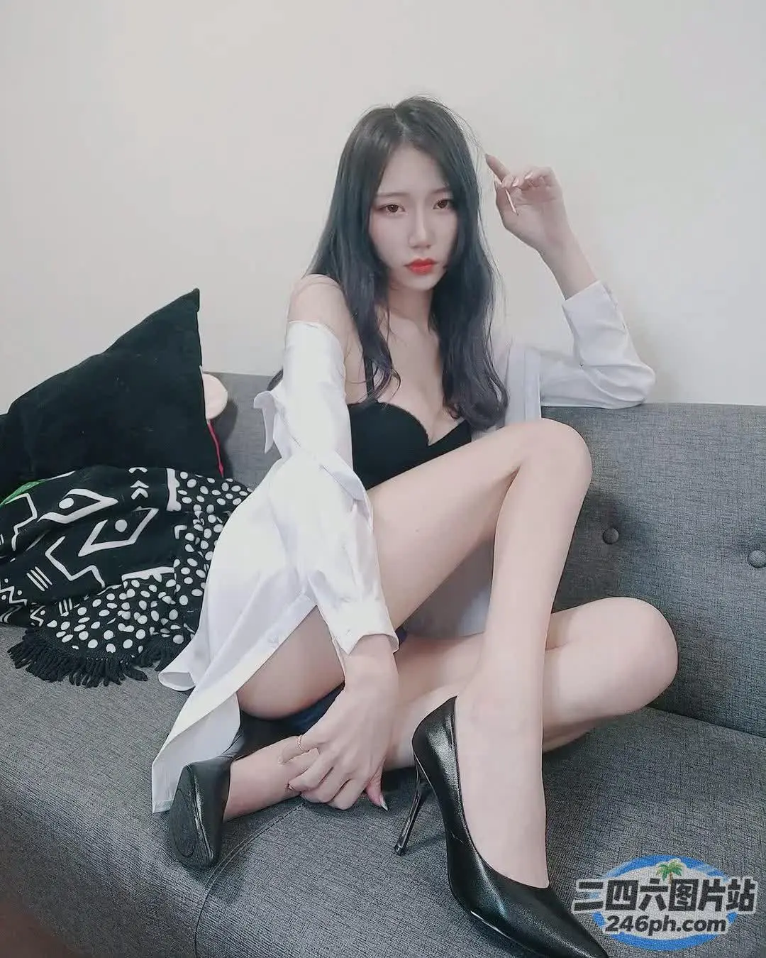 一个穿着高跟鞋坐在沙发上的女人的特写