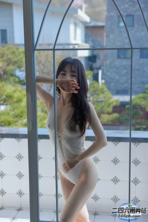身穿白色连衣裙的 Araffes 在窗前摆姿势
