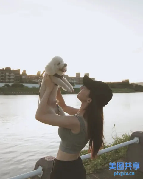 阿拉法德女子在水体附近举着一只狗