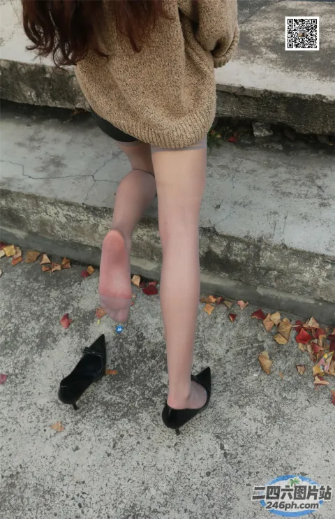 穿着毛衣和黑色鞋子的 Araffed 女人站在台阶上