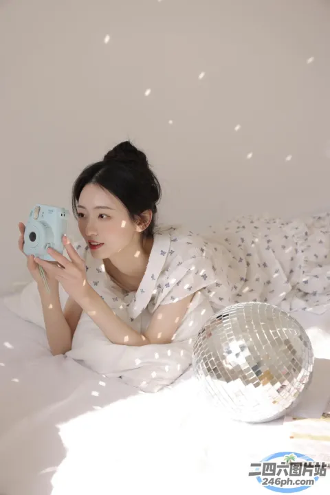 躺在床上用相机拍镜球的女人