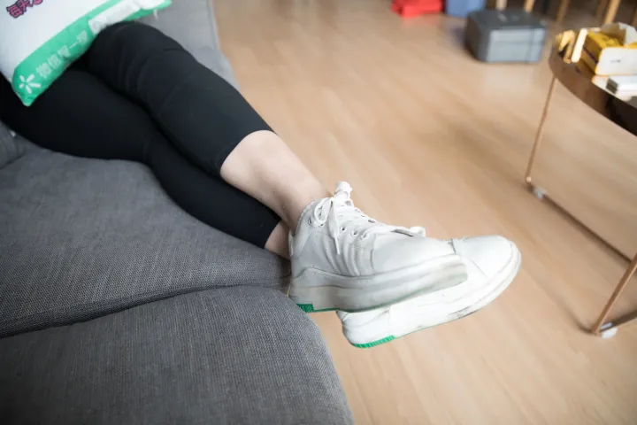 有人坐在沙发上，双脚抬起