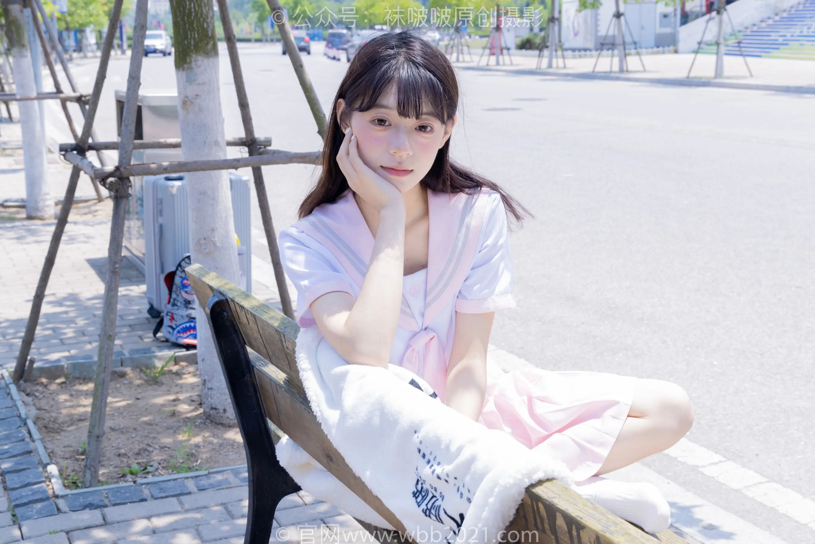 有个女人坐在长凳上，手放在下巴上