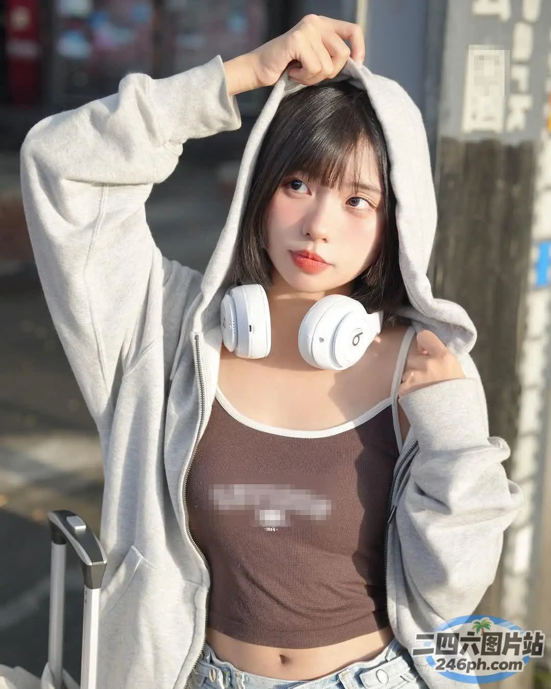头戴耳机、提着行李箱的亚洲女性
