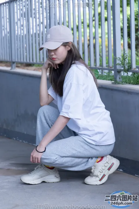 穿着白色衬衫和灰色裤子的 araffe 女孩蹲在滑板上