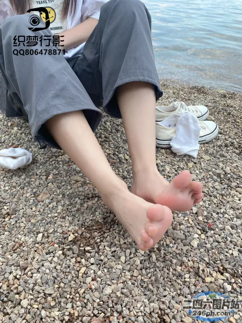有一个女人坐在海滩上，双叉