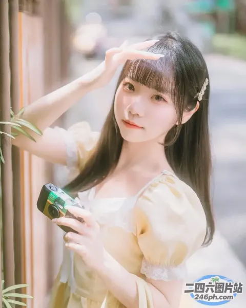 一个穿着黄色连衣裙的女人拿着相机的特写