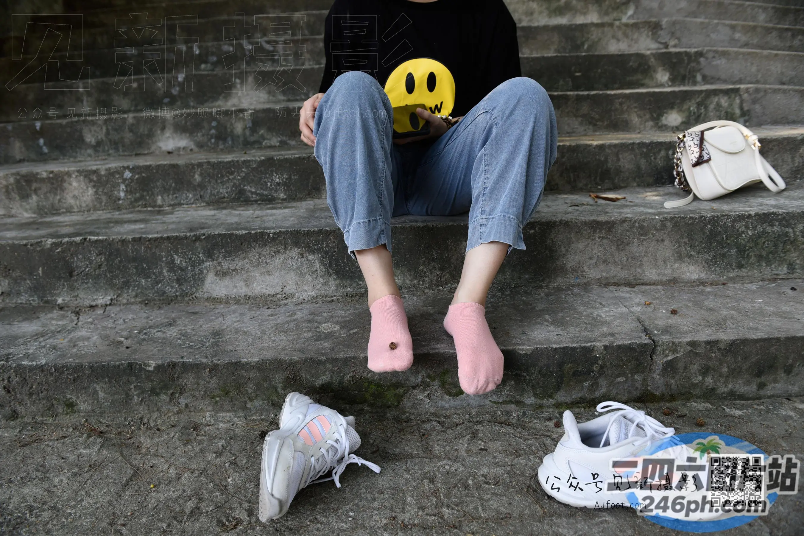阿拉菲坐在台阶上，手里拿着一个笑脸球