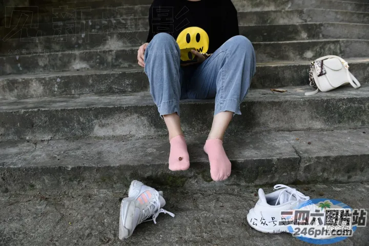 阿拉菲坐在台阶上，手里拿着一个笑脸球
