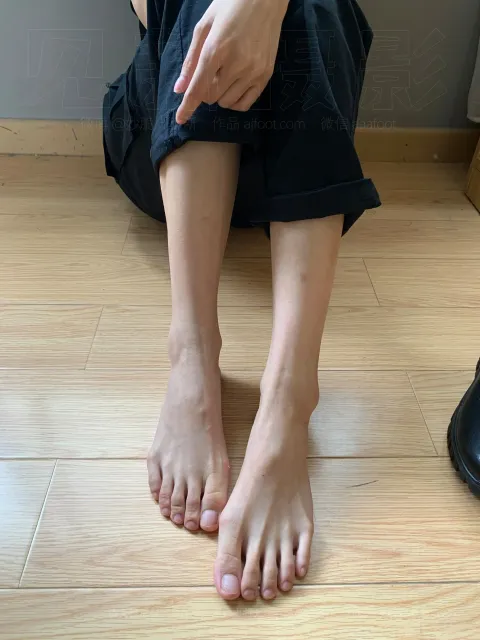 有一个女人坐在地板上，双叉