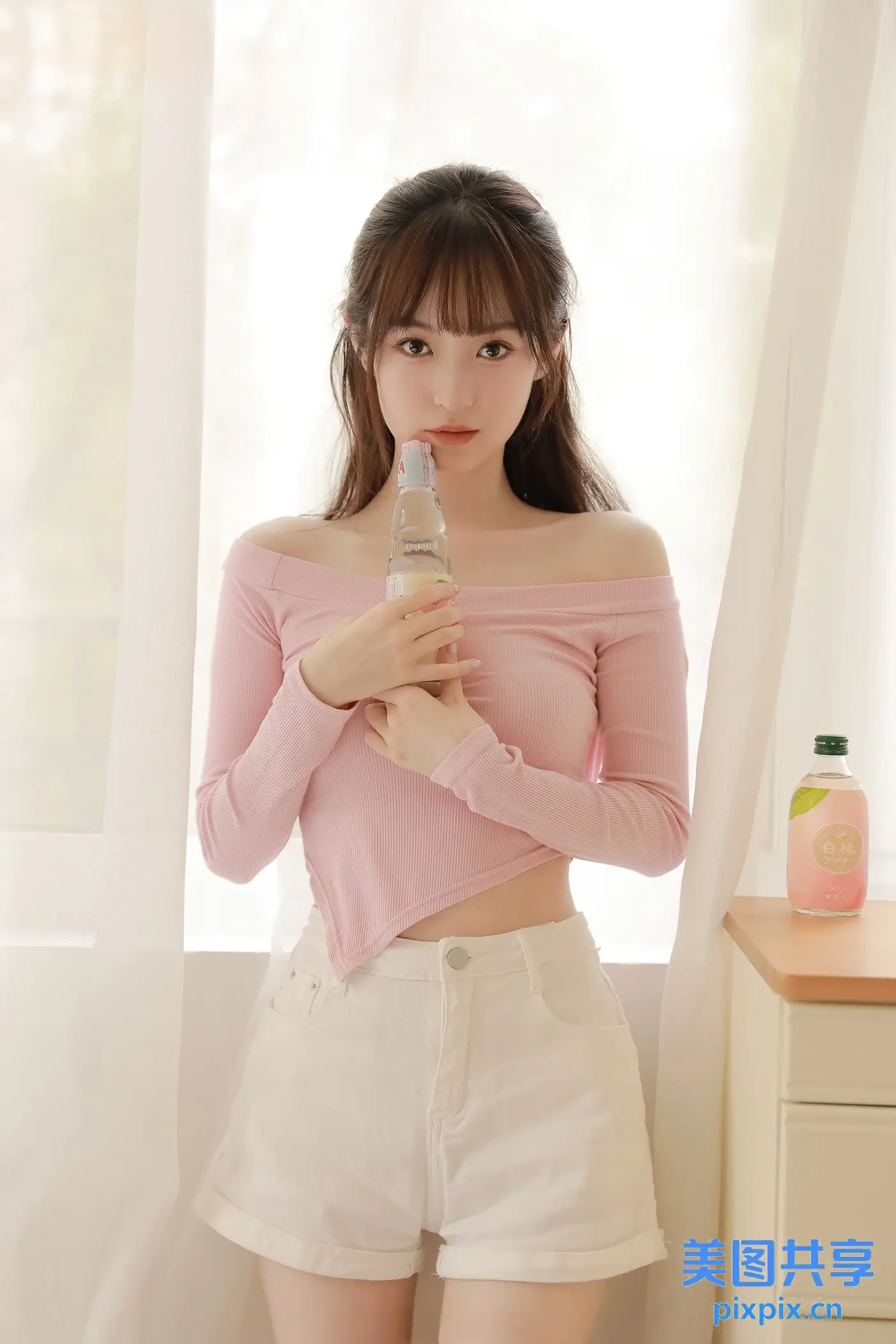 身穿粉色上衣和白色短裤拿着手机的阿拉夫女人