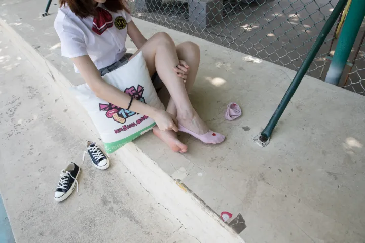 有一个女人穿着鞋子坐在地上