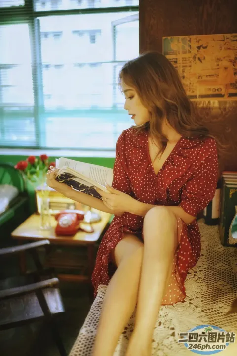 坐在房间里的床上看书的女人