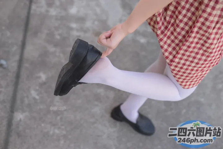 穿着裙子和鞋子的人拿着鞋子的 Araffed 视图