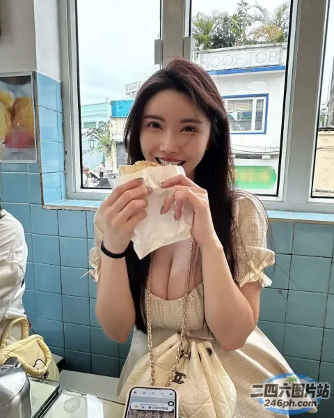 女子在餐厅用手机吃三明治