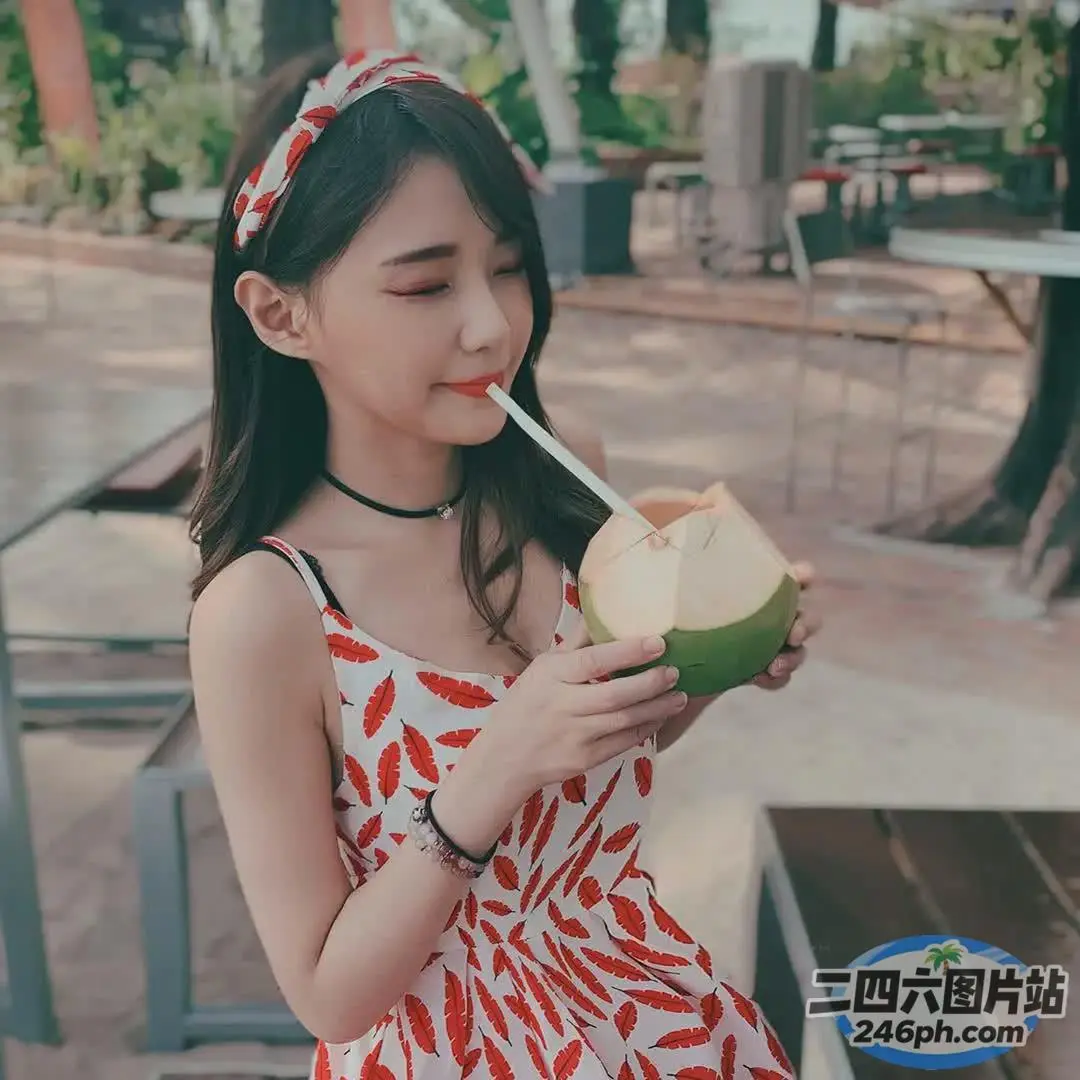 一个女人手里拿着椰子饮料的特写