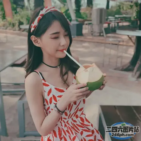 一个女人手里拿着椰子饮料的特写