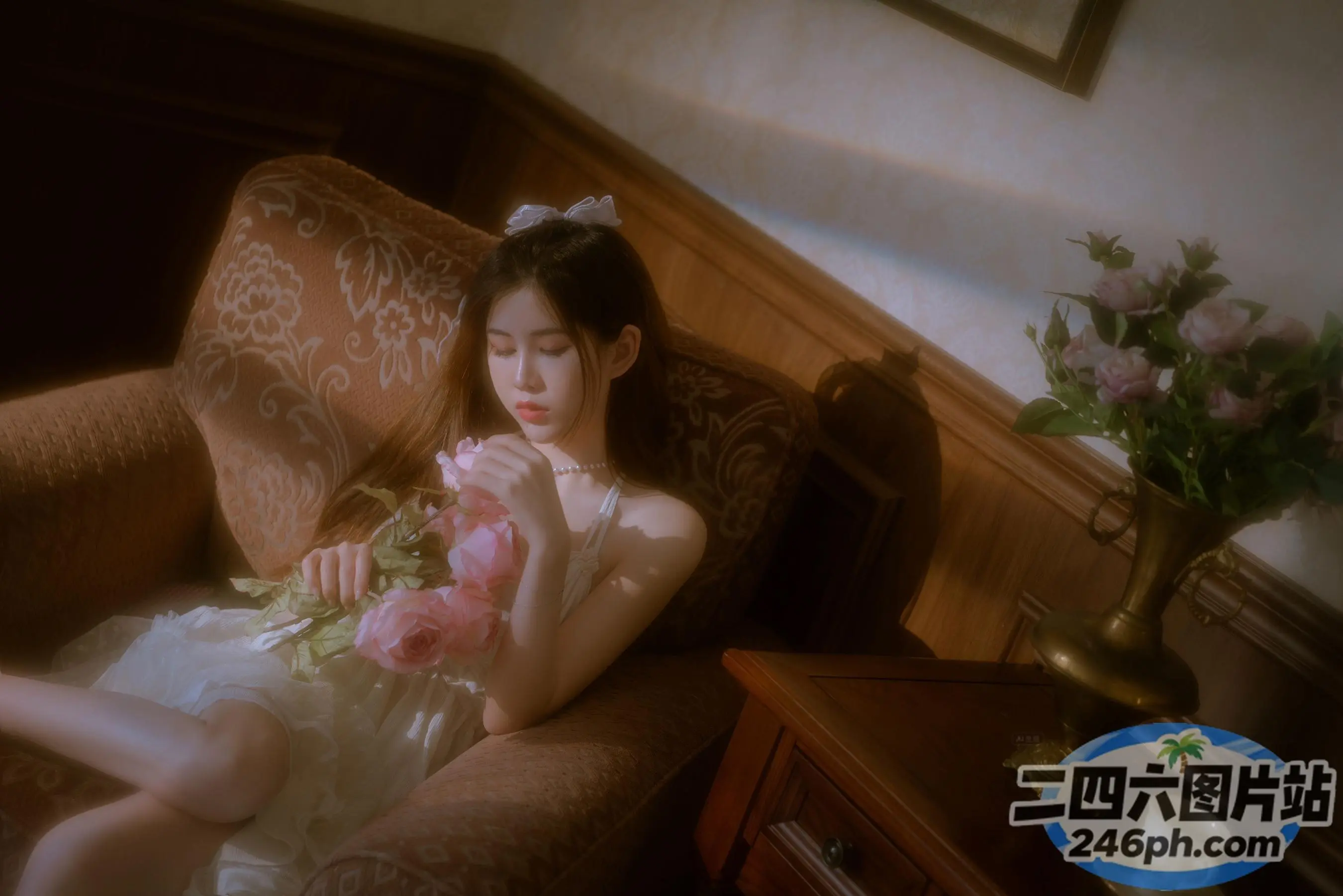有一位女士坐在椅子上，手里拿着一束鲜花