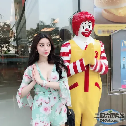 身穿碎裙的女人站在罗纳德一世的雕像旁
