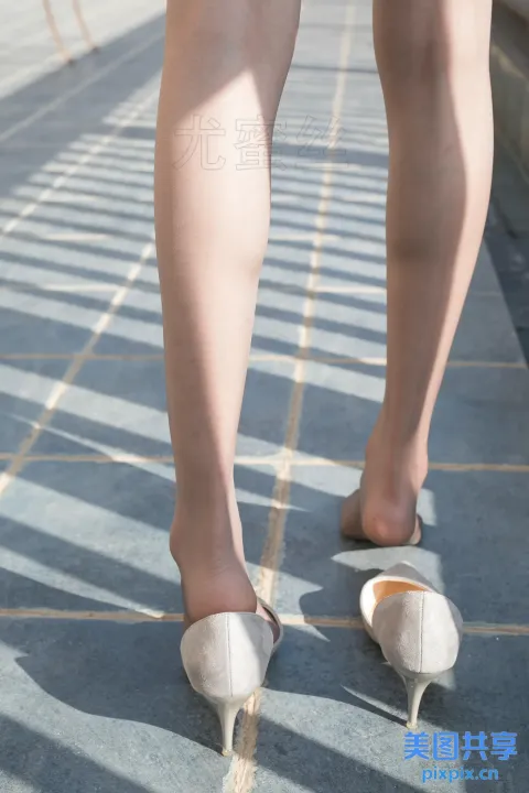 人行道上有个穿着高跟鞋的女人的腿