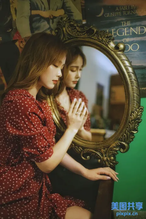 有一个女人坐在镜子前看着她的倒影
