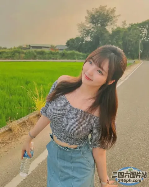 一名女子站在田野附近的道路上的特写