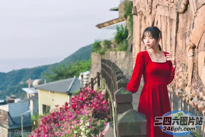 站在石墙上的红裙子的阿拉菲女人