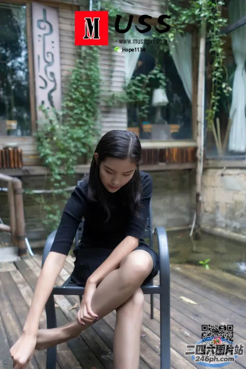 有个女人坐在长凳上，双腿交叉