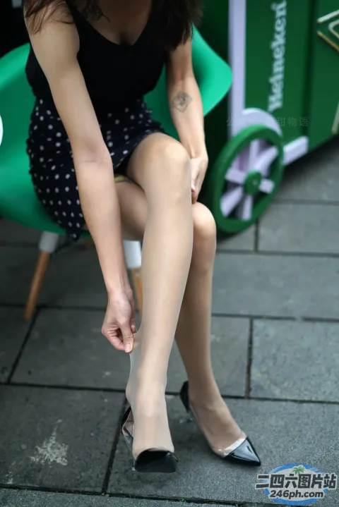 阿拉菲女子坐在绿色椅子上，双腿交叉
