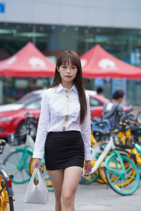 穿着裙子和白衬衫走在街上的女人