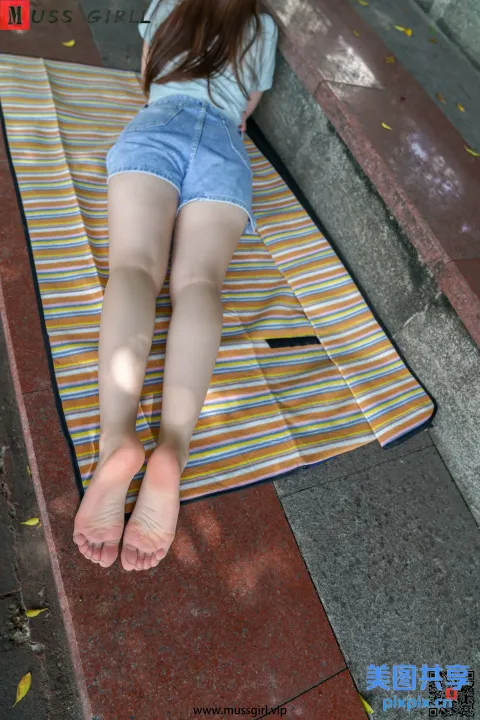 阿拉夫德女人躺在地上的毛巾上，双脚抬起
