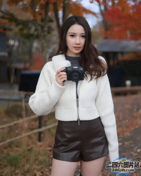 身穿白色毛衣和黑色短裤的 araffe 女子拿着相机